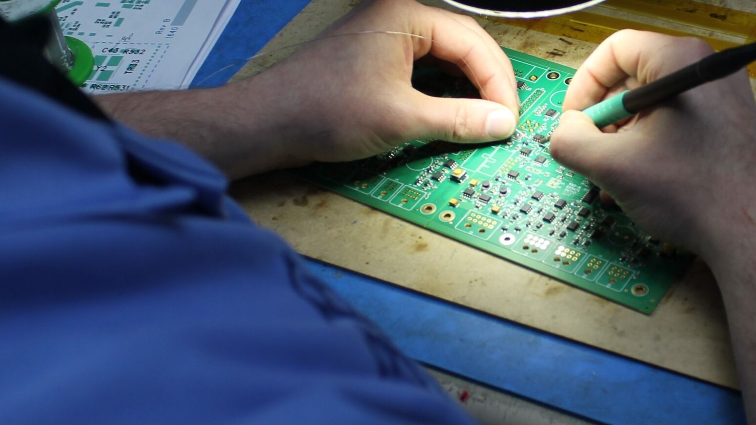 A man hand soldering a circuit board
