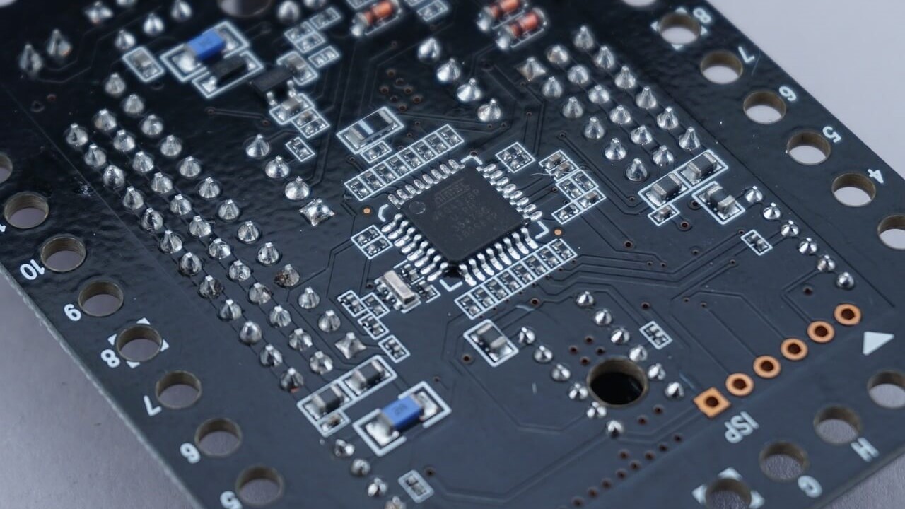 A black circuit board with a microcontroller on it.